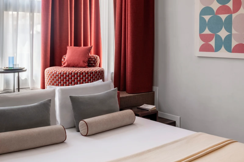 Deluxe room detail with bed, armchair and red curtains - Parioli Cube Hotel, BZAR hotels in Rome