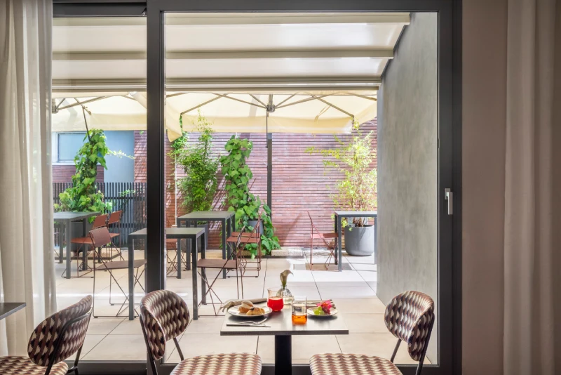 Breakfast room with a set table and outdoor terrace with parasols - Parioli Cube Hotel, BZAR hotels in Rome
