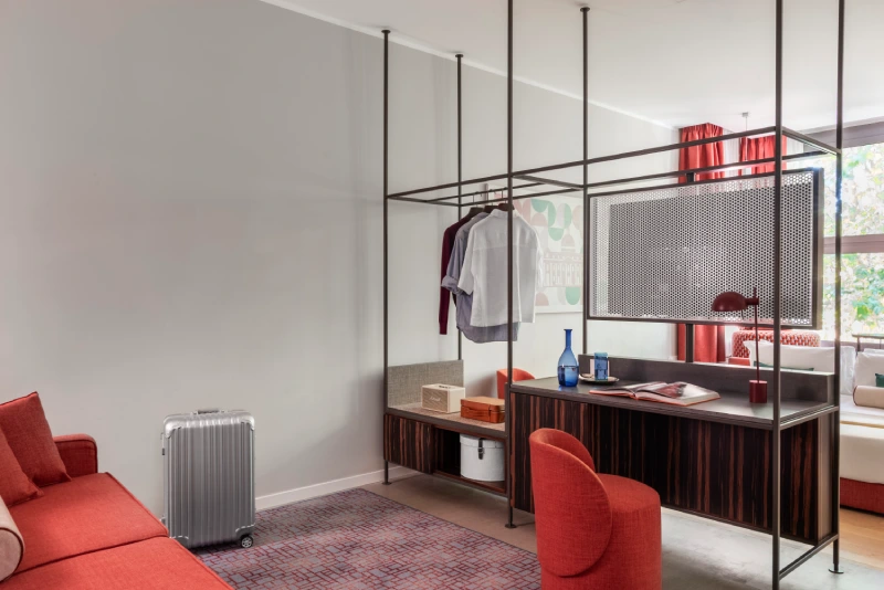 Junior Suite living area with red sofa, desk and open wardrobe - Parioli Cube Hotel, BZAR hotels in Rome